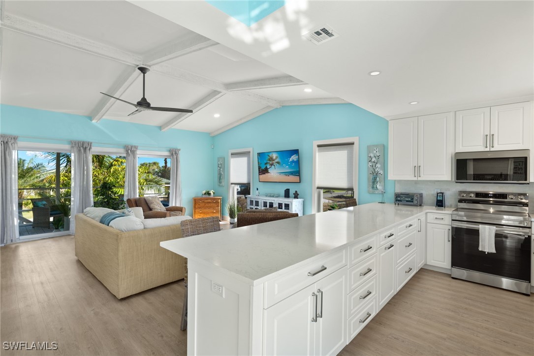 a large living room with stainless steel appliances granite countertop a couch and a view of living room