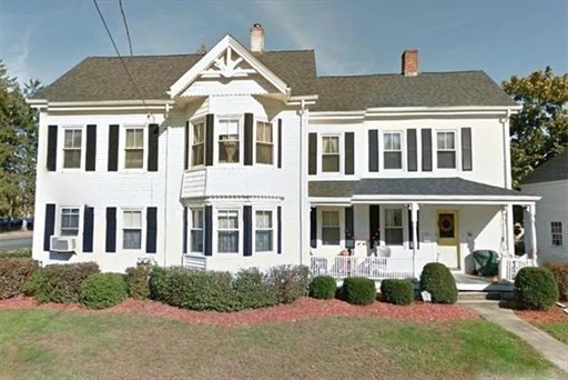 a front view of a residential houses with yard