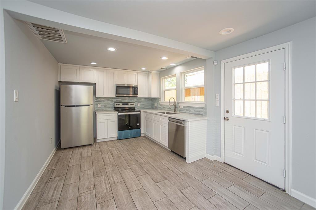 a kitchen with stainless steel appliances granite countertop a refrigerator and a stove top oven