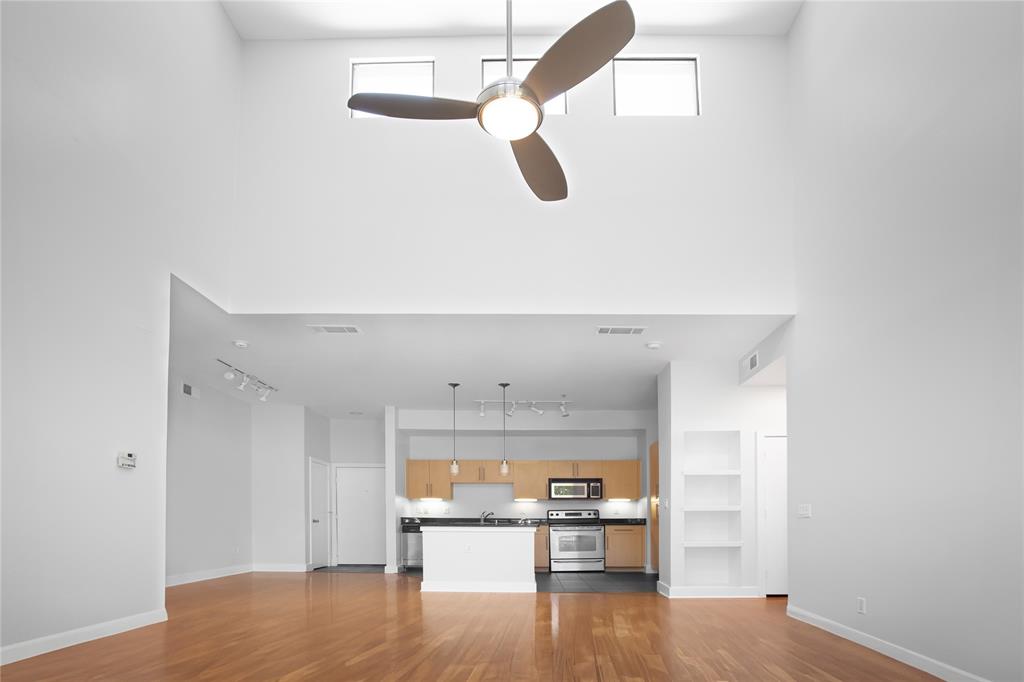 a room with kitchen view and wooden floor