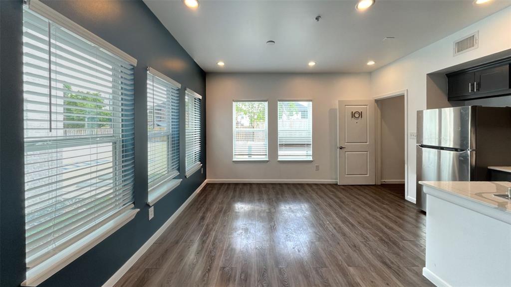 a view of entryway with kitchen and wooden floor