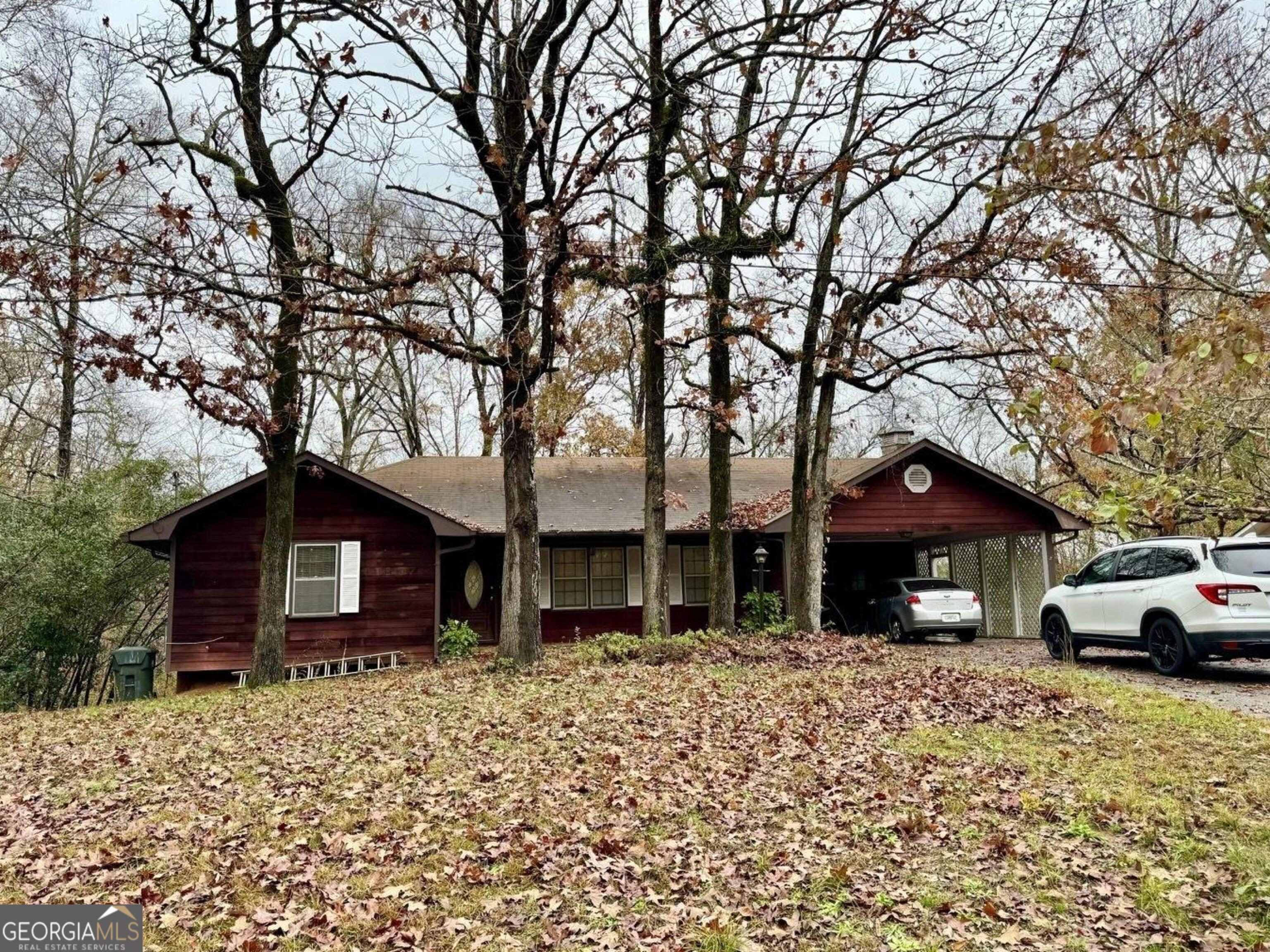 a front view of a house with a yard and trees