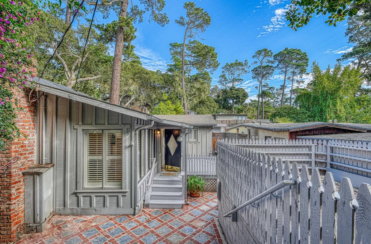 a view of a house with a small yard and wooden deck