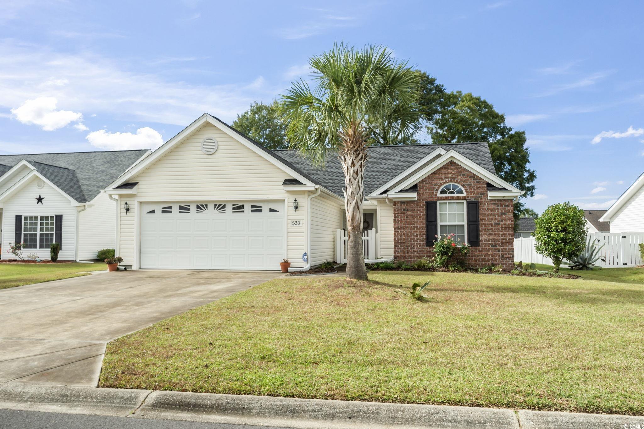 Single story home with a garage and a front yard