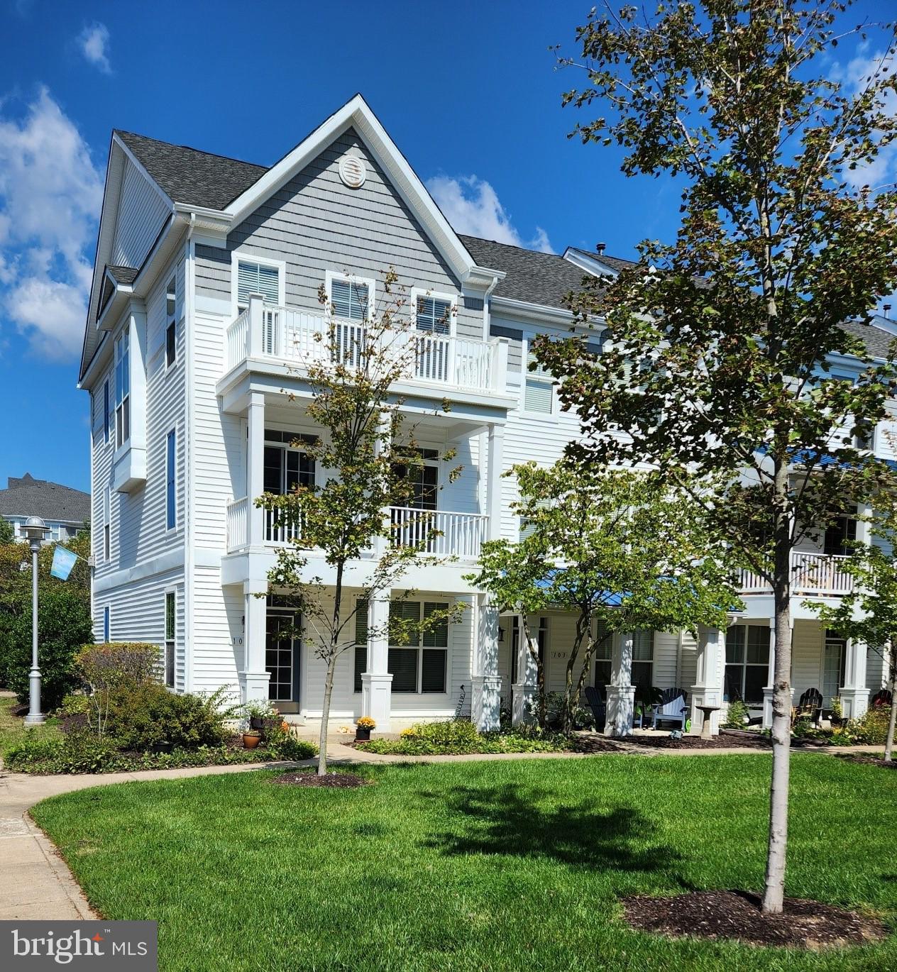 a front view of white house with a yard