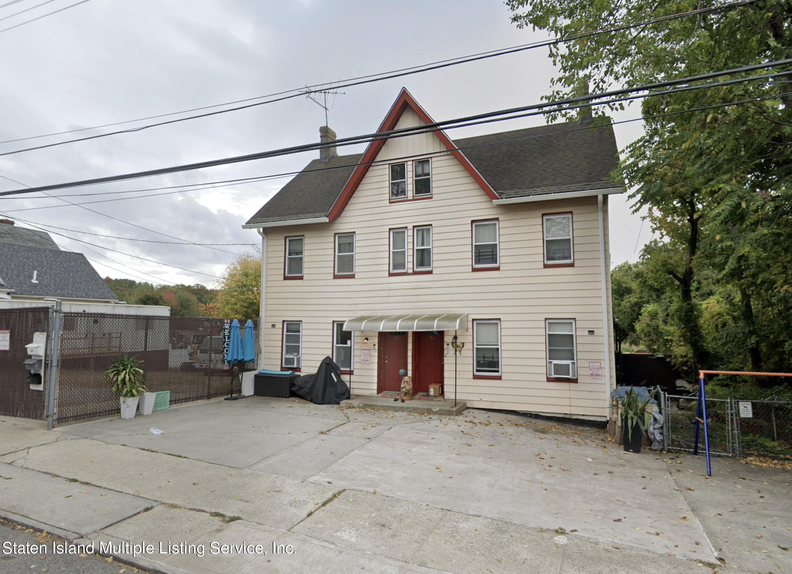 a view of a house with a patio and a yard