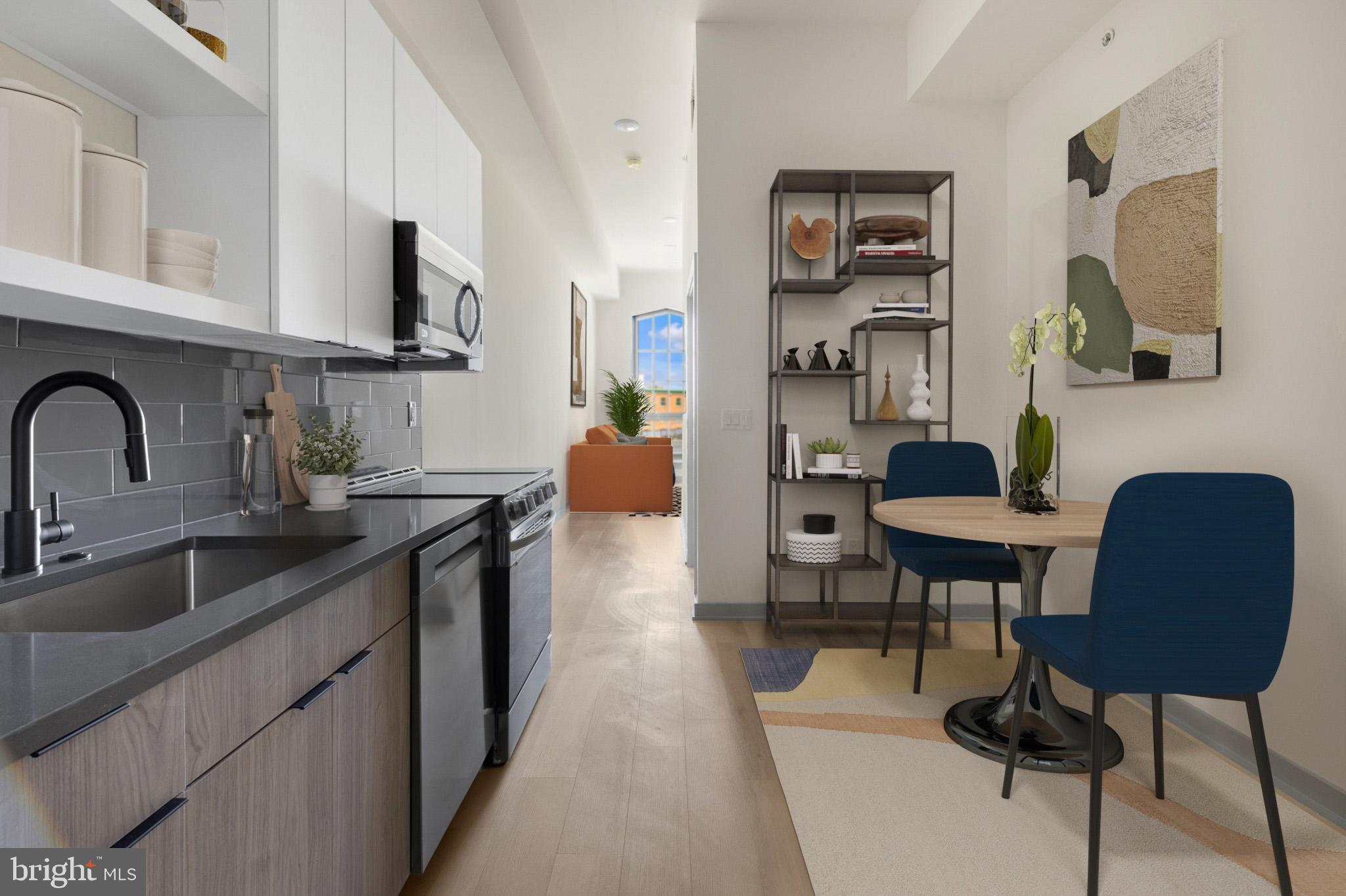 a kitchen with stainless steel appliances kitchen island a table chairs sink and cabinets