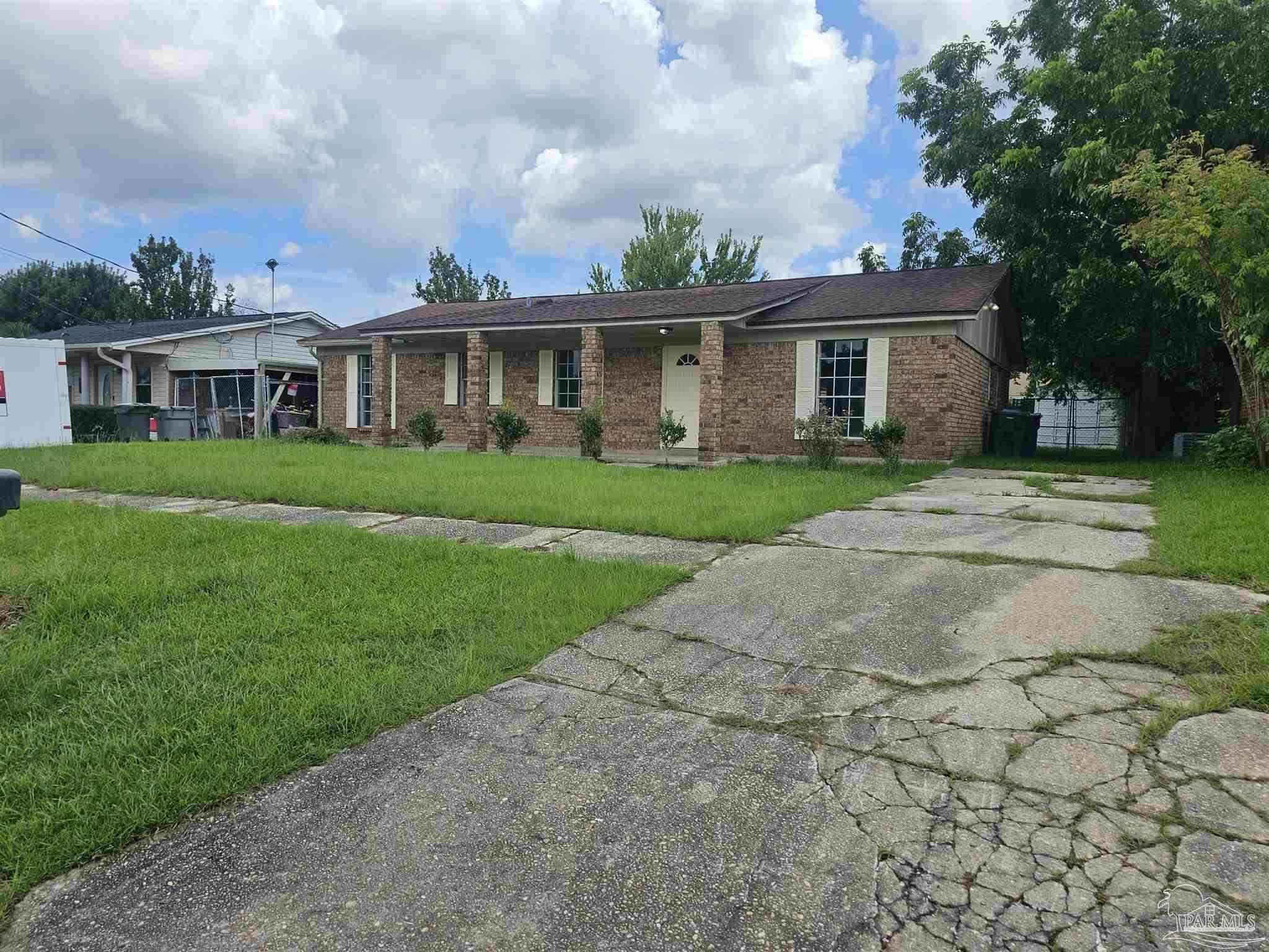 a front view of a house with a garden and plants