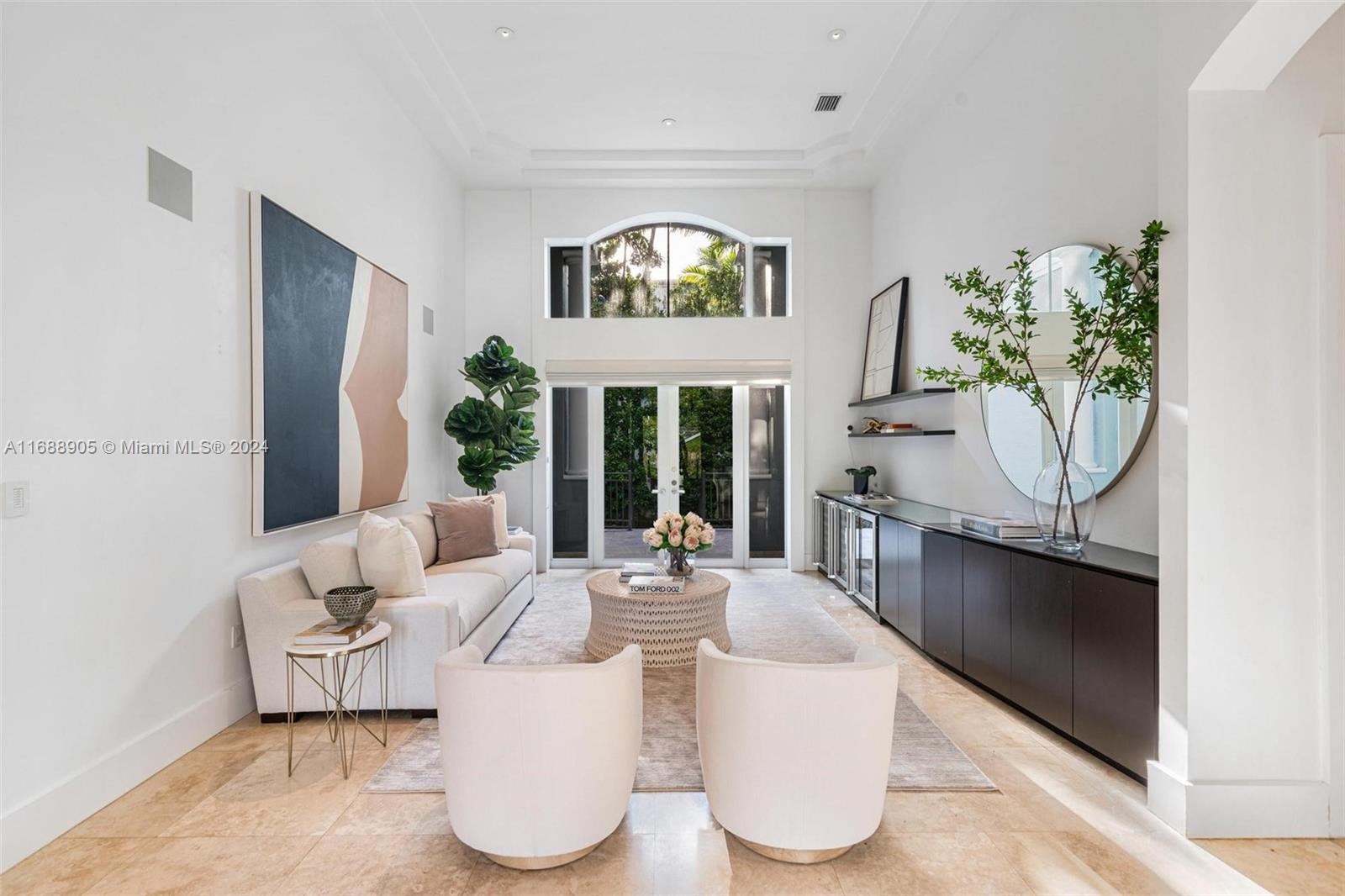 a living room with couches a fireplace and a large window with garden view