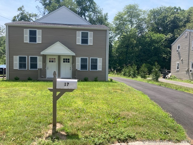 a front view of a house with yard and green space