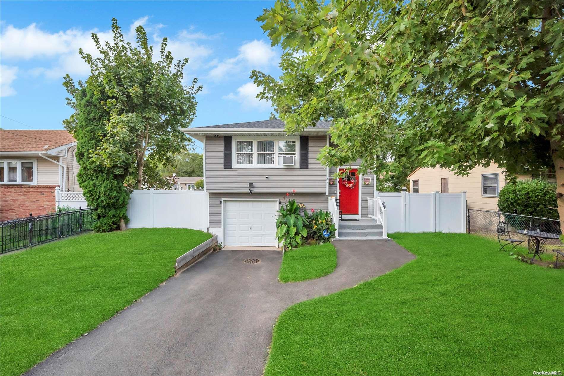 a front view of a house with a yard and trees