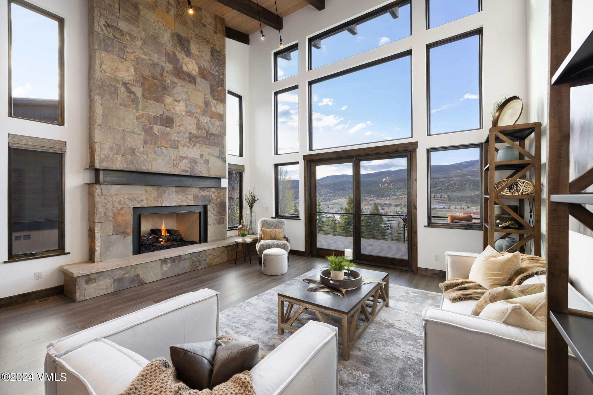 a living room with furniture fireplace and floor to ceiling windows