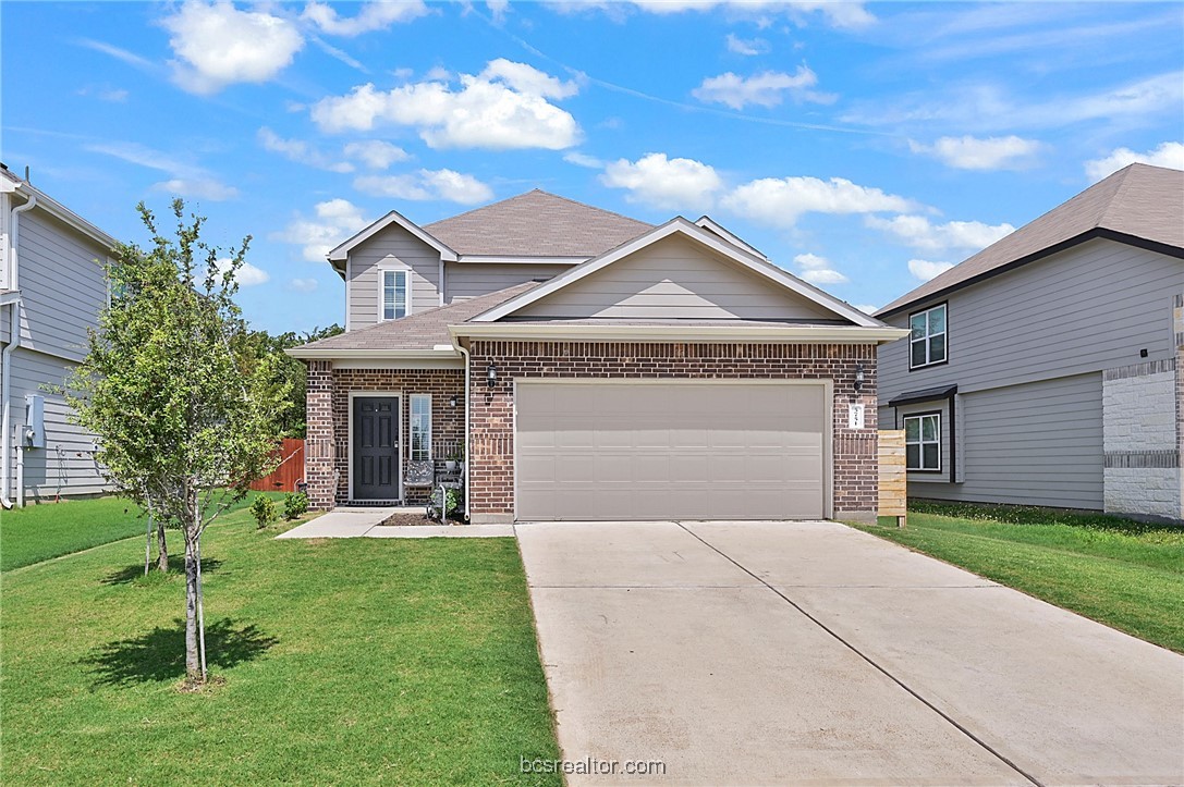 a front view of a house with a yard and garage