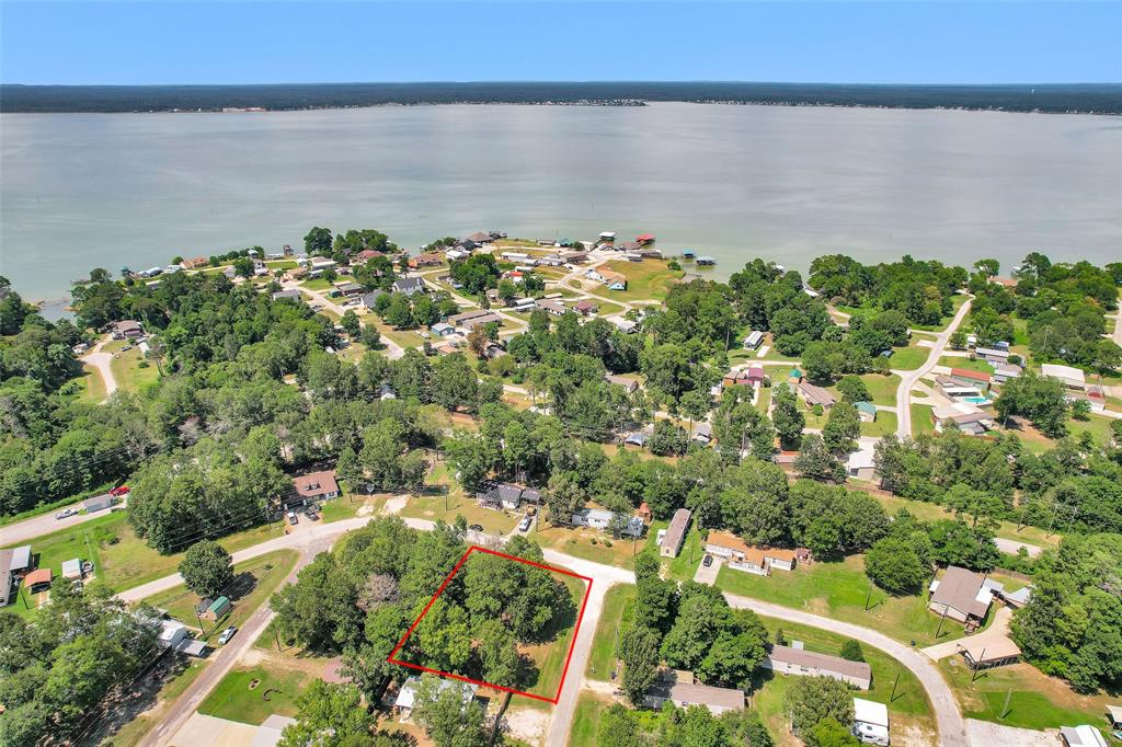 an aerial view of a houses with a lake and trees all around