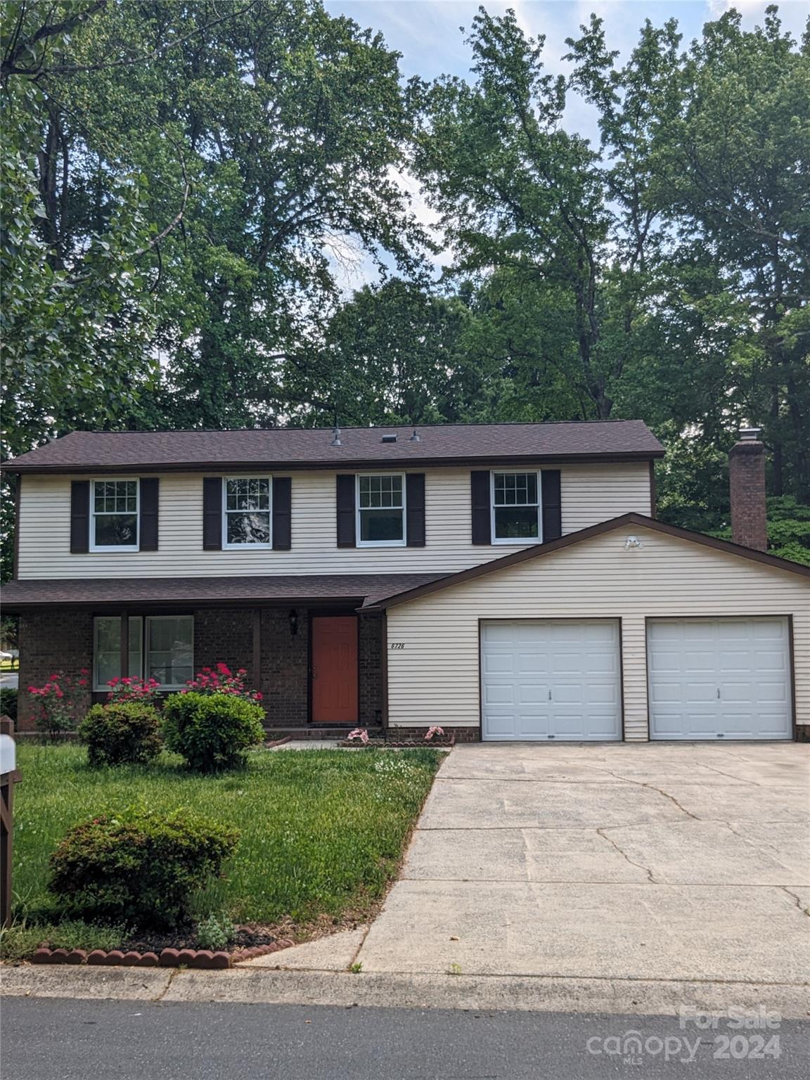 a front view of a house with a garden and garage