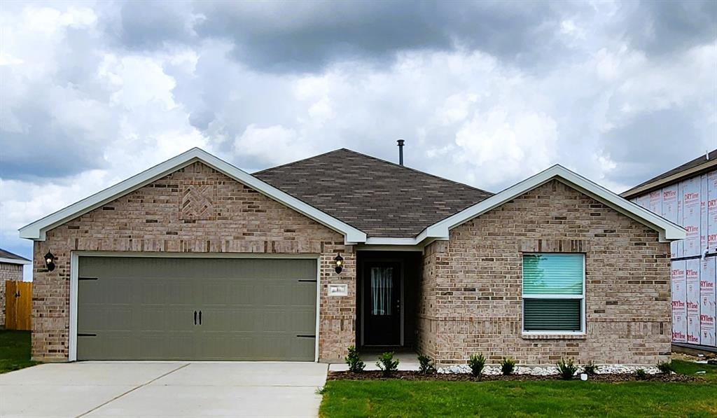 a front view of a house with a garden and yard