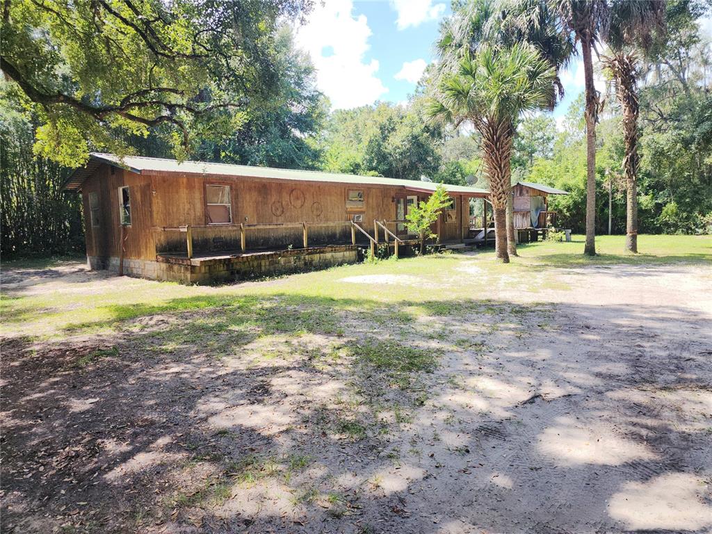 a view of a house with backyard and trees