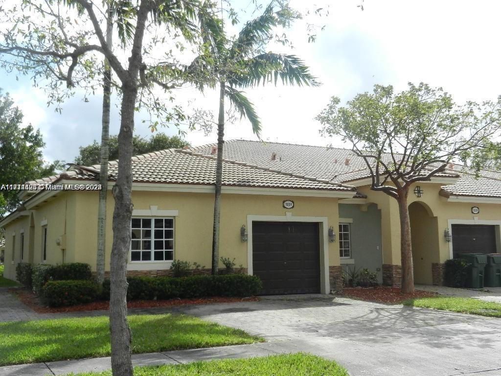 a front view of a house with a yard and potted plants