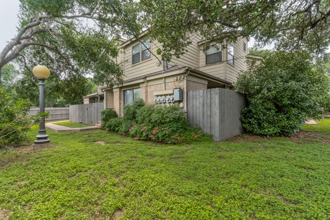 a view of backyard of house with green space