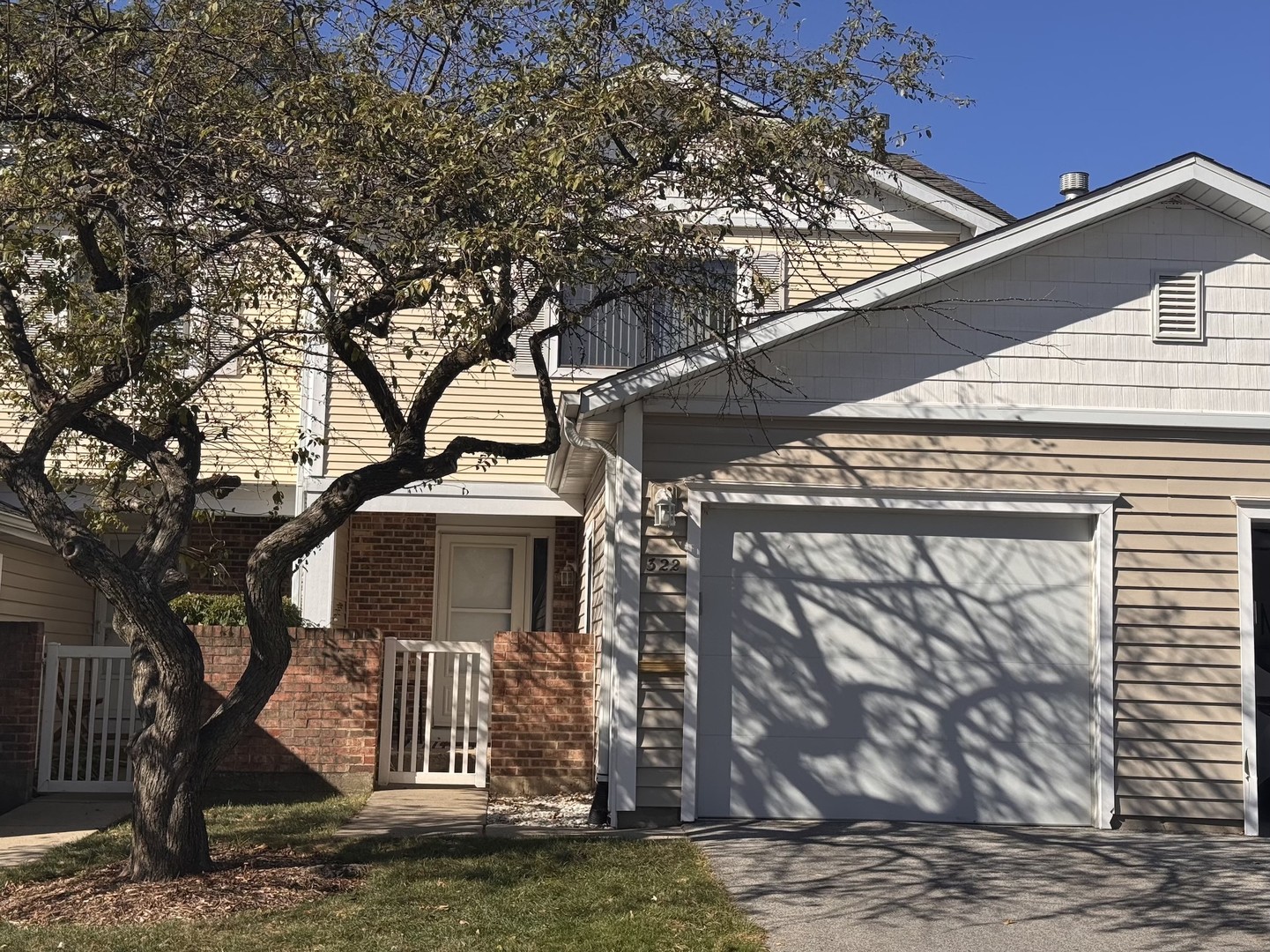 a front view of a house with a tree