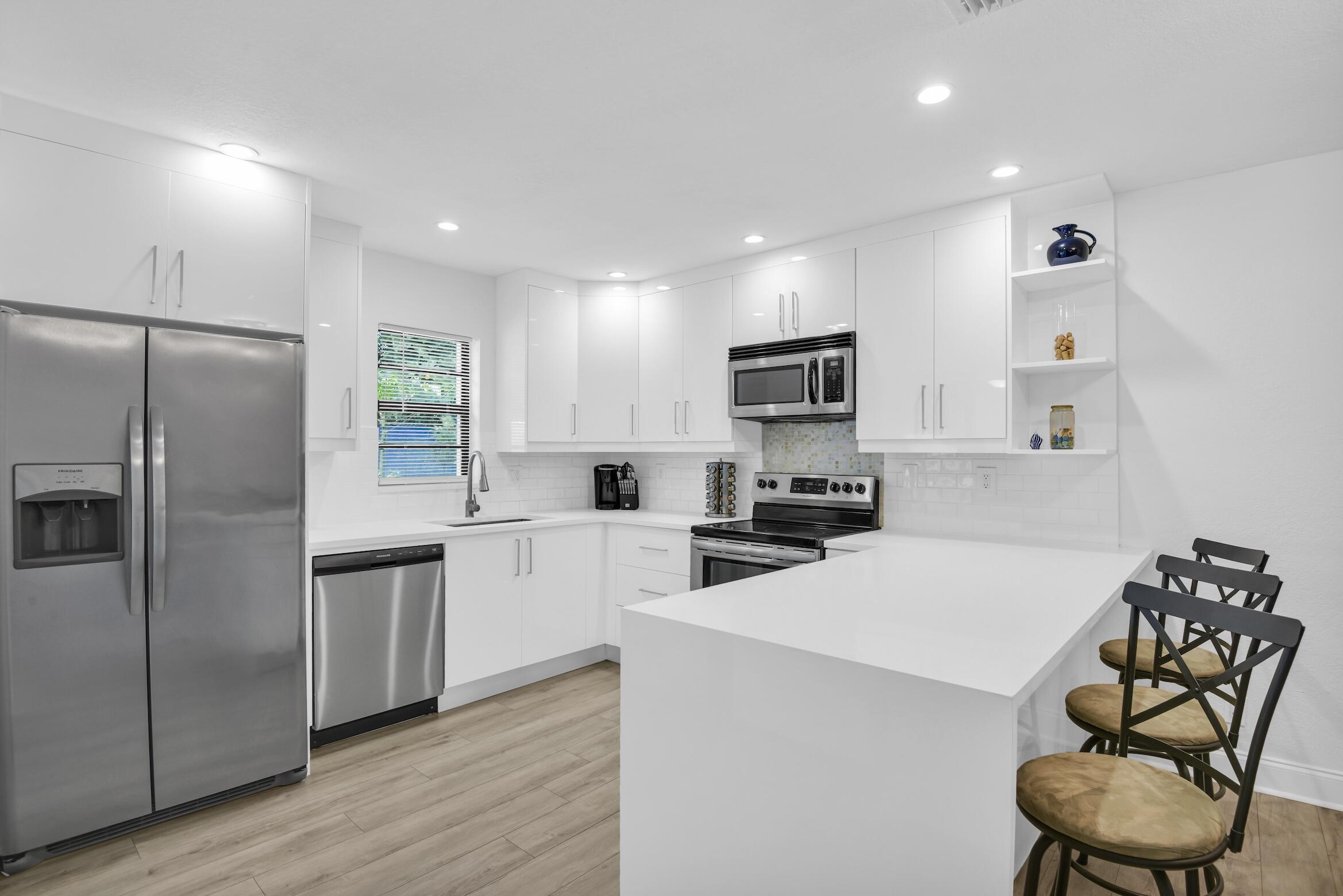 a kitchen with a refrigerator a stove cabinets and a sink