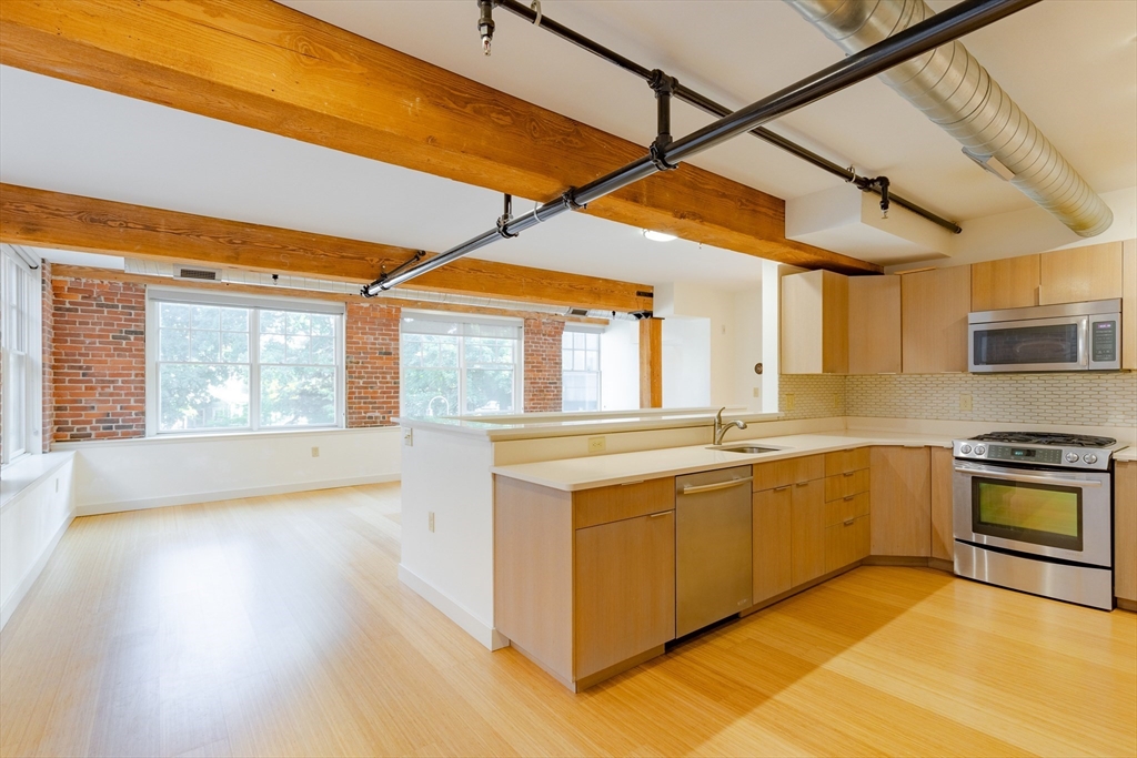 a kitchen with stainless steel appliances granite countertop a sink and a stove