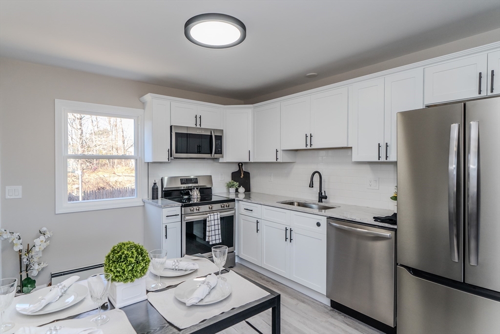 a kitchen with stainless steel appliances granite countertop a refrigerator sink and stove