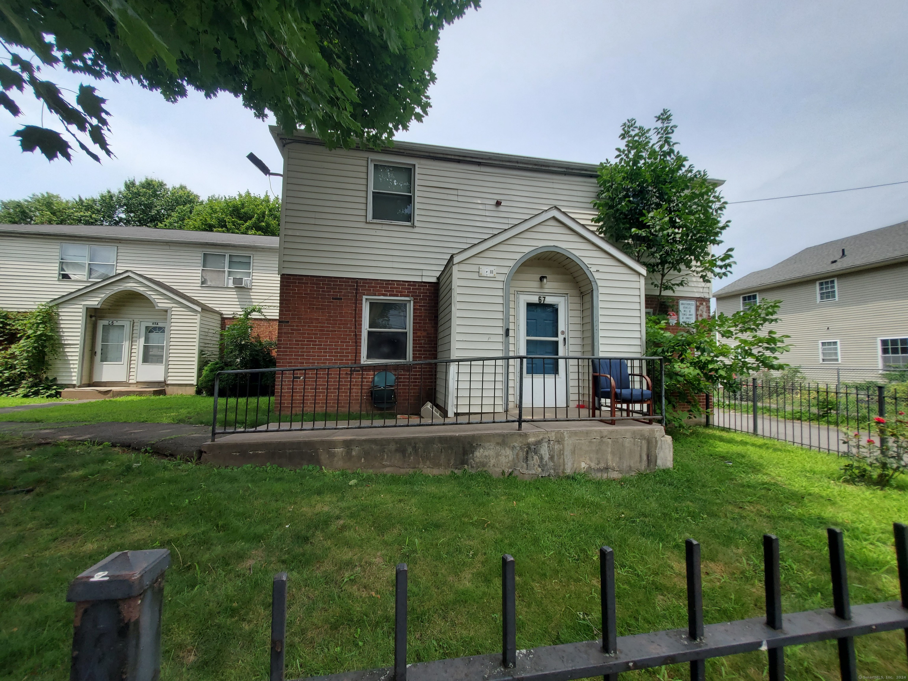 a front view of a house with a yard and potted plants