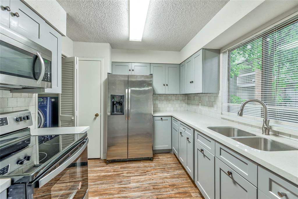 a kitchen with stainless steel appliances a refrigerator sink and microwave