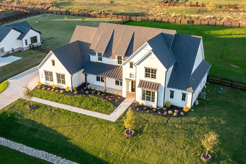 an aerial view of a house with a garden and lake view