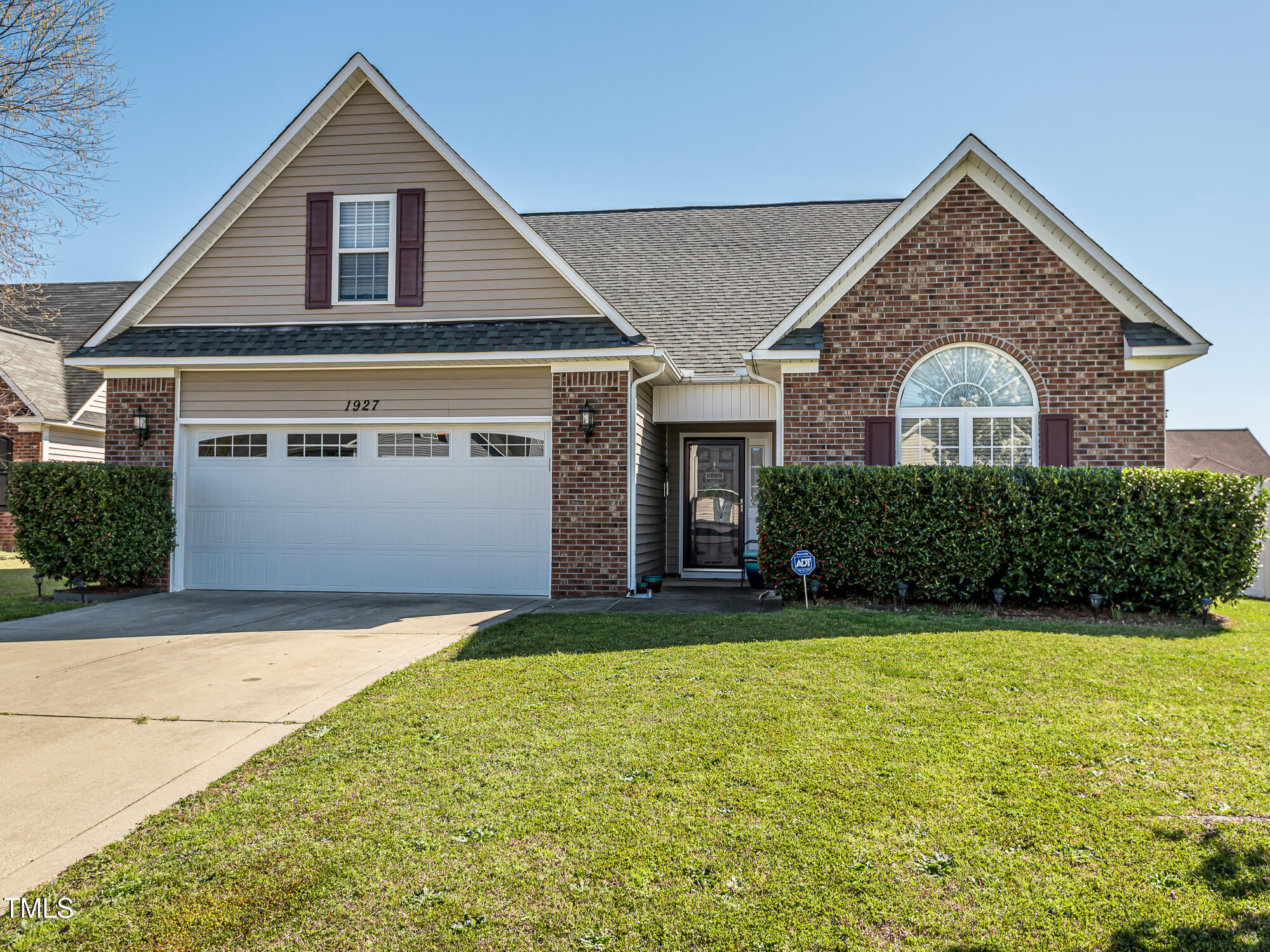 a front view of a house with yard and garage