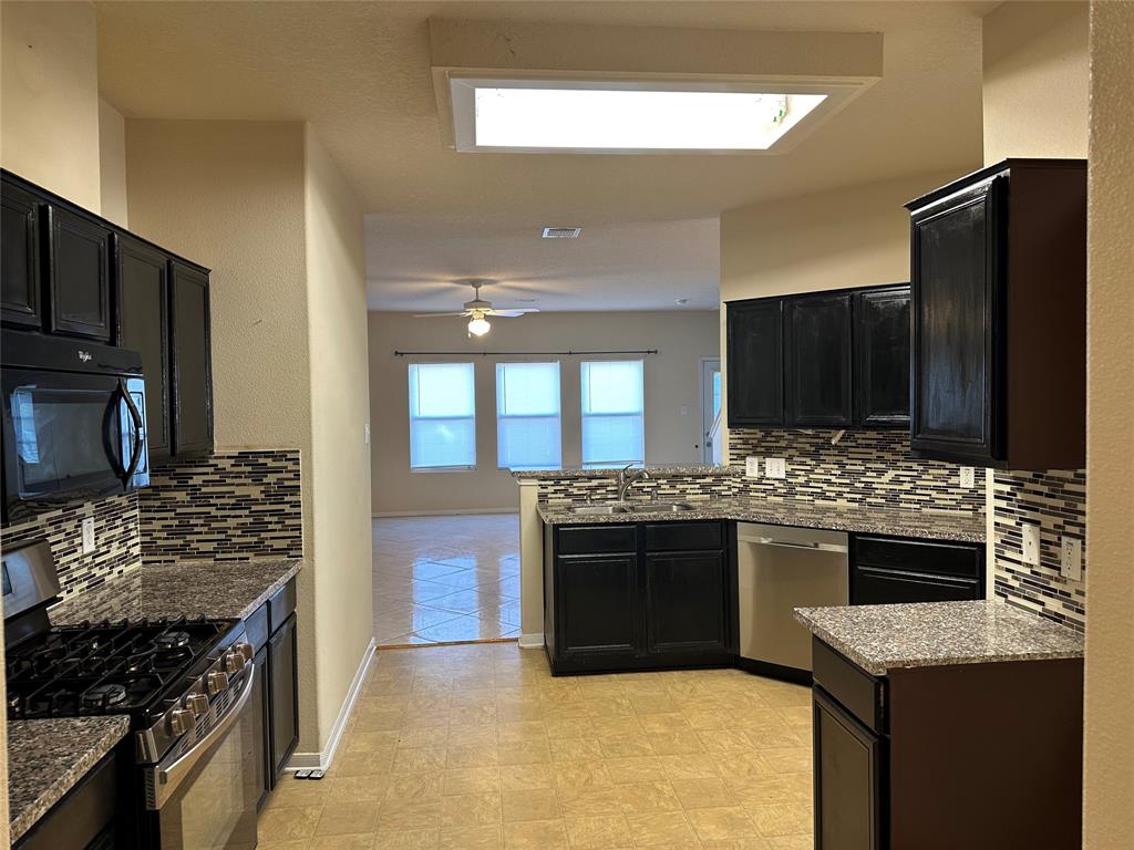 a kitchen with stainless steel appliances granite countertop a stove and a refrigerator