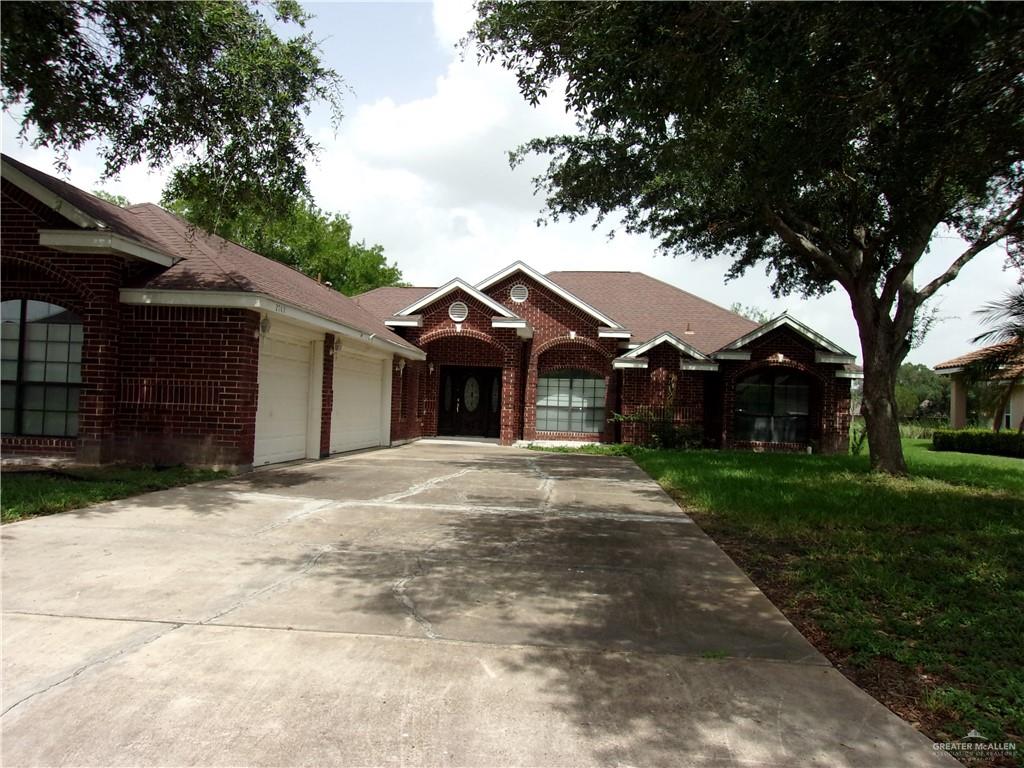 a front view of a house with a garden and trees