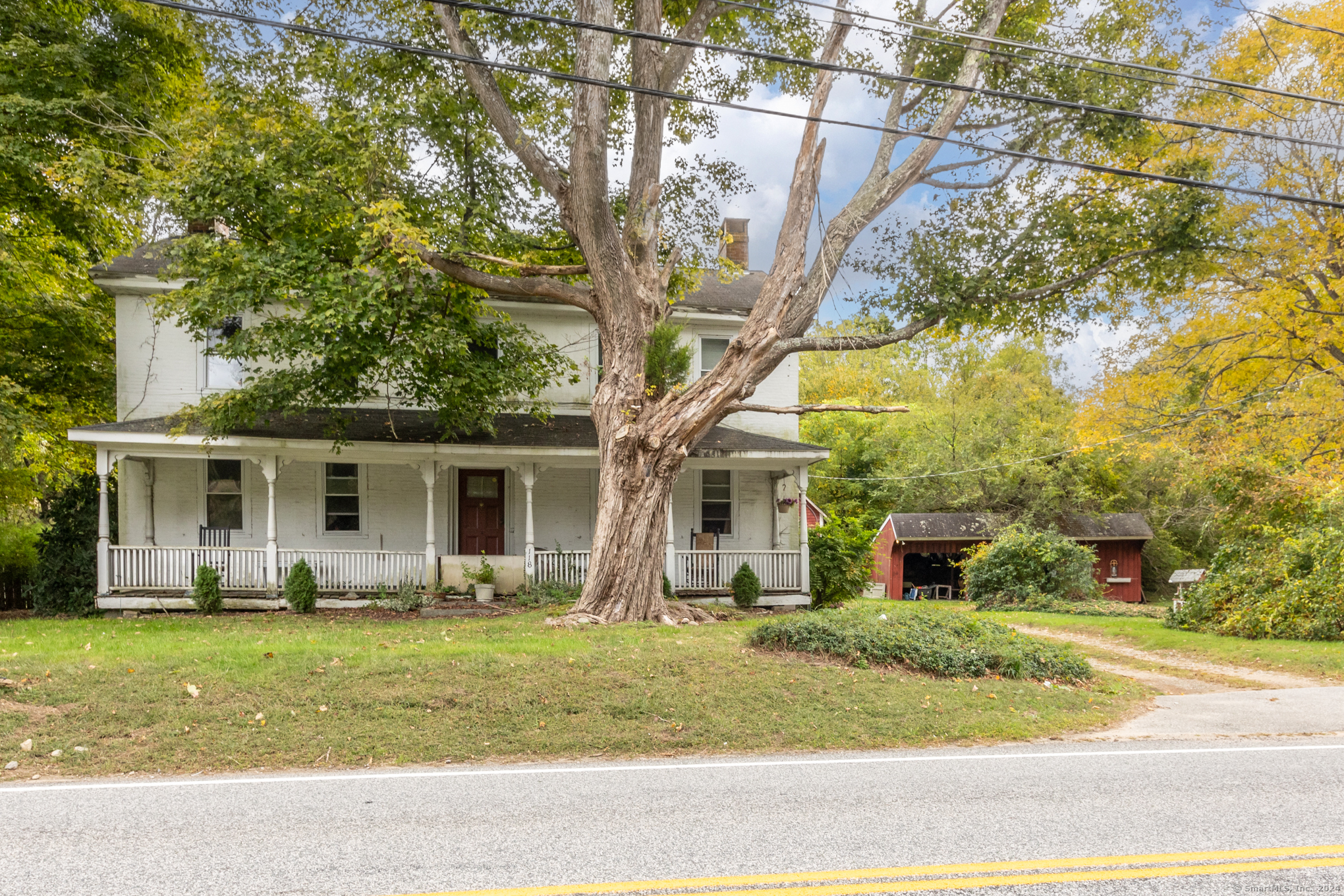 a front view of house with yard and trees in the background