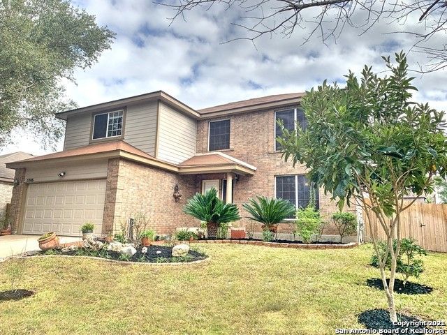 a front view of house with yard and trees around