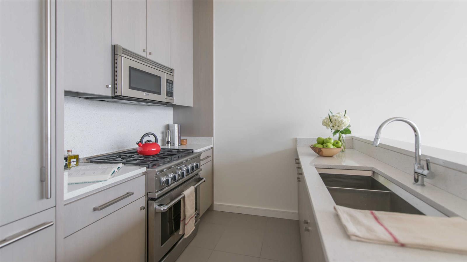 a kitchen with stainless steel appliances granite countertop a sink and a stove top oven