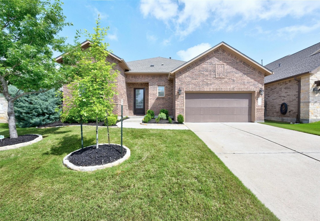 a view of an house with backyard and a tree