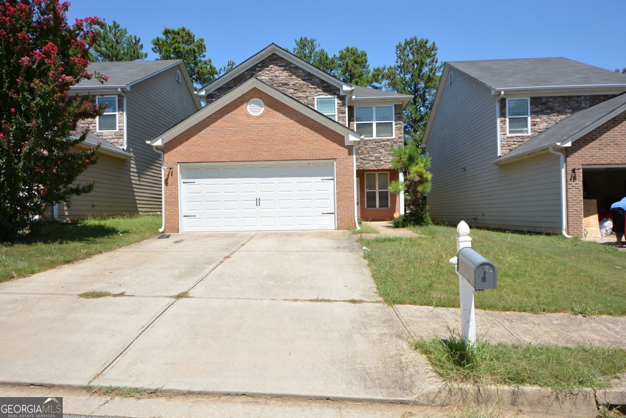 a front view of a house with a yard and garage