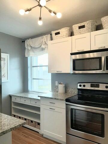 a kitchen with stainless steel appliances a stove and a microwave