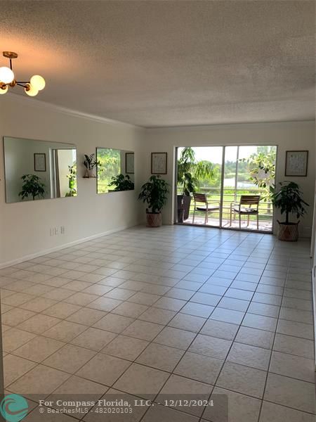 an empty room with floor to ceiling window and outdoor view