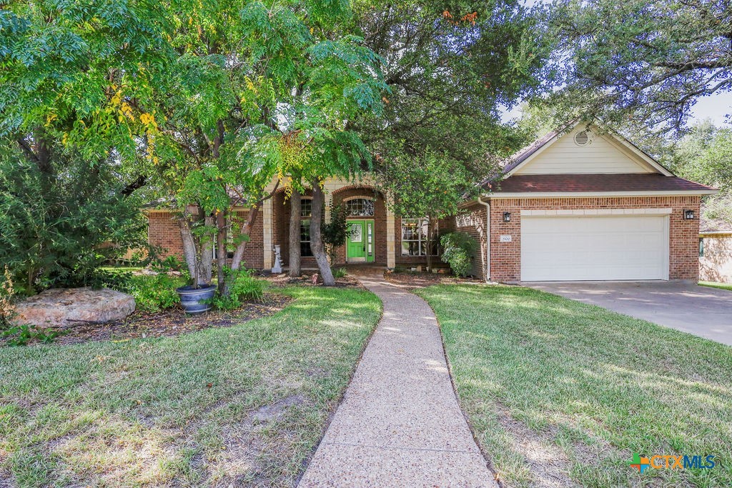 a front view of a house with yard and green space