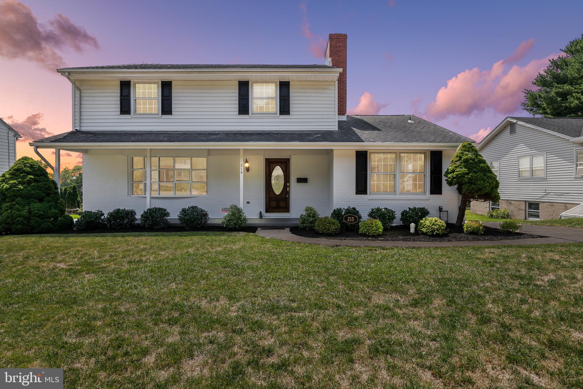 a front view of a house with a yard and potted plants