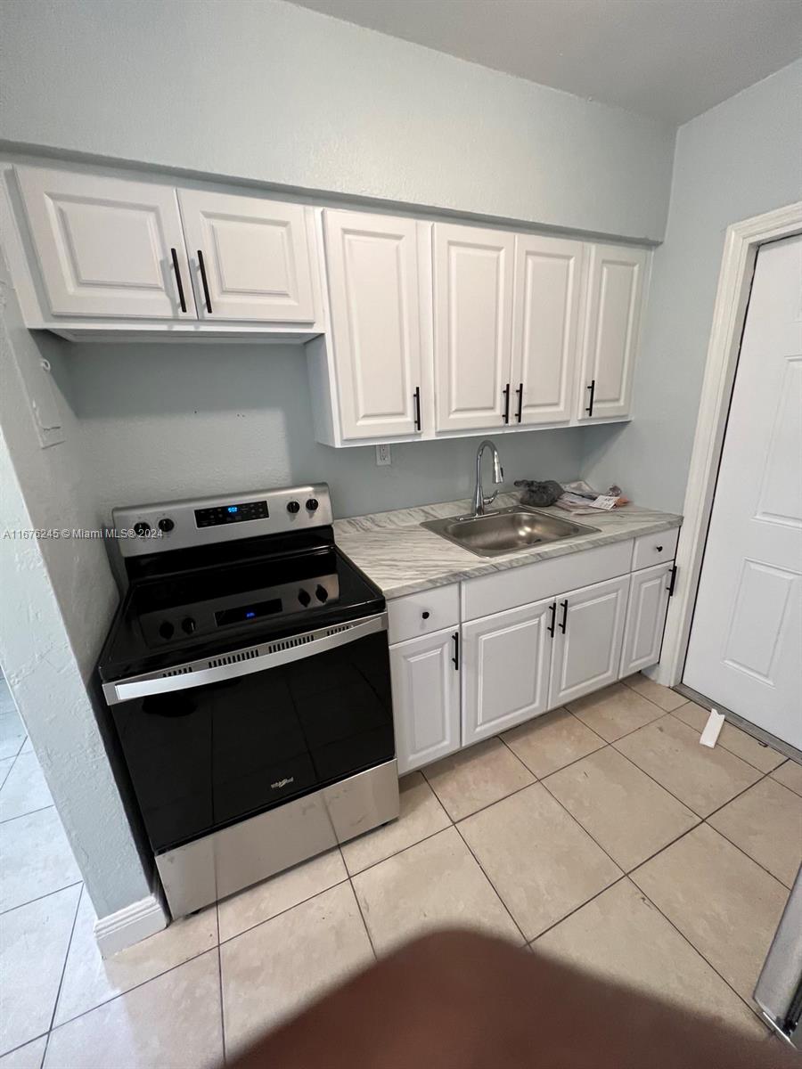 a kitchen with a sink a stove and cabinets