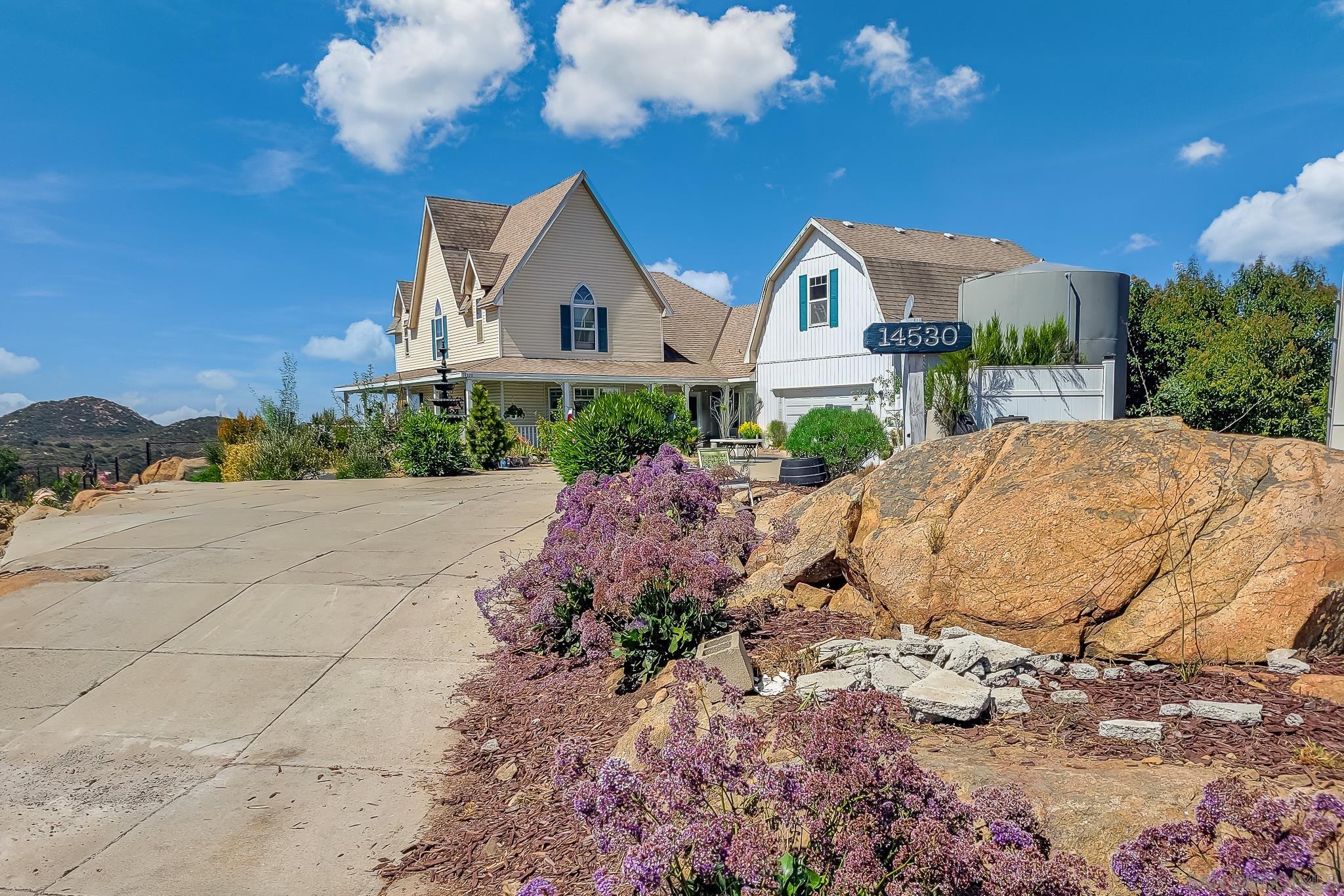 a view of a house with a yard and potted plants