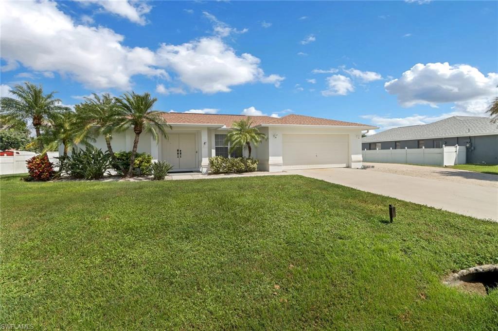 View of front of home featuring a front yard and a garage