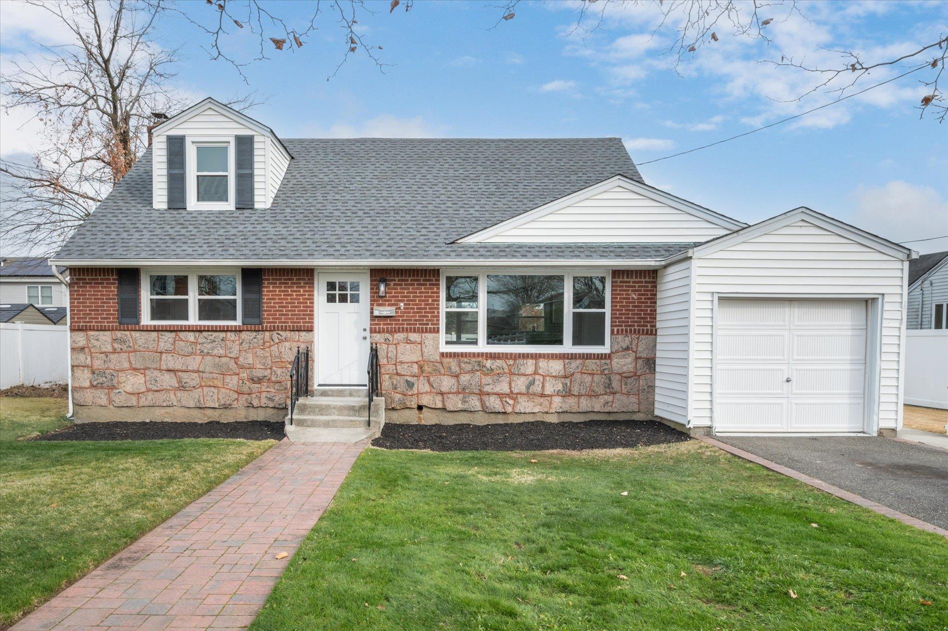 View of front of home featuring a garage and a front lawn