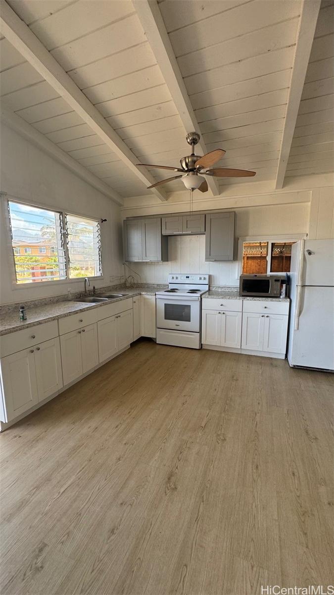 a large kitchen with a large window a counter space stainless steel appliances and cabinets