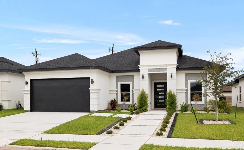 Prairie-style home featuring a garage and a front yard