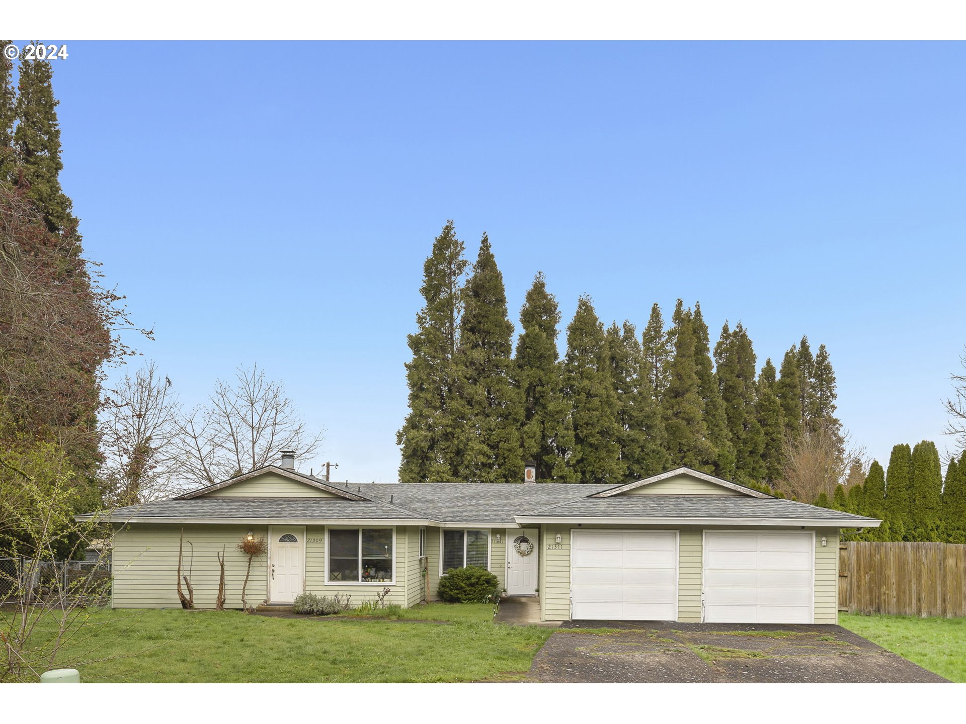 a view of a yard in front of a house with a tree