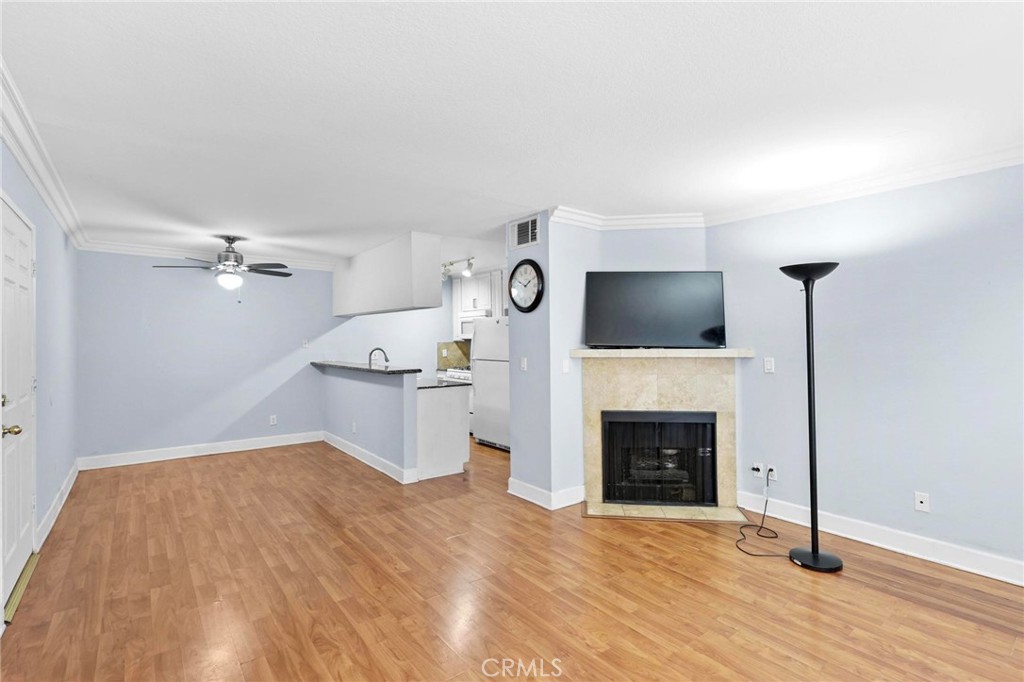 a view of a livingroom with wooden floor and a fireplace